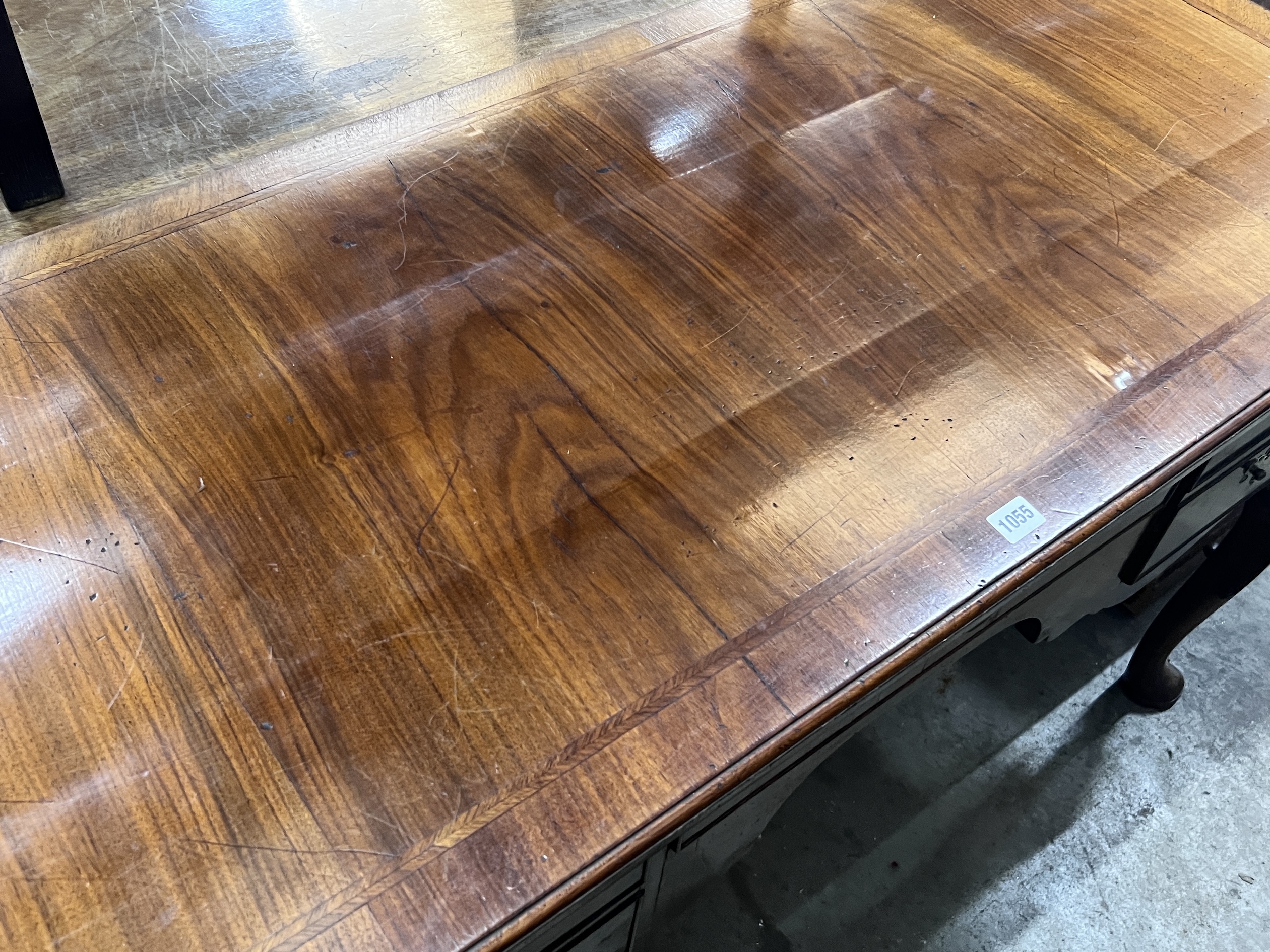 A Queen Anne revival feather banded walnut kneehole dressing table, width 129cm, depth 58cm, height 78cm